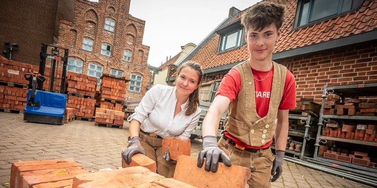 Azubis der Kirchenbauhütte sortieren Backsteine