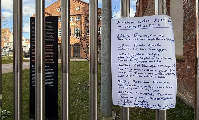 Handgeschriebener Zettel am Zaun der Lübecker Synagoge