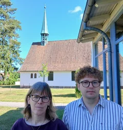 Eine Frau und ein Mann stehen vor einer Kirche.