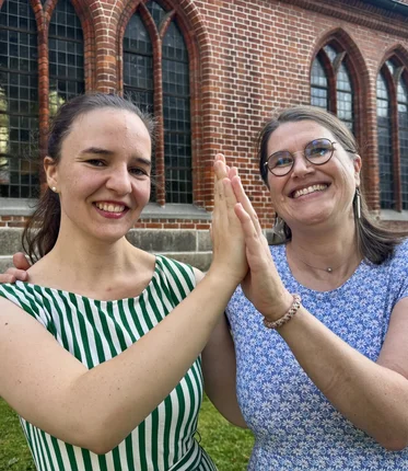 Zwei Frauen vor einer Kirche