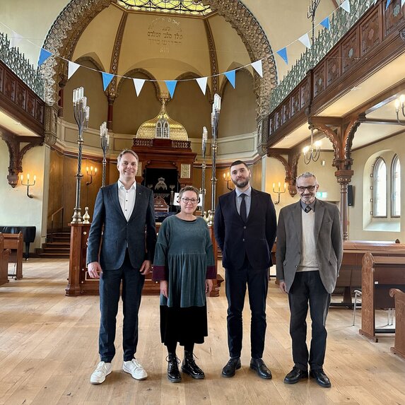 Vier Personen in einer Synagoge