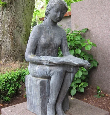 Die Skultptur einer lesenden Frauenfigur vor St. Lorenz Schmilau