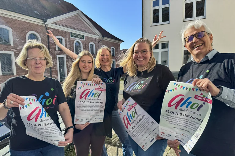 Menschen mit Plakaten schauen in die Kamera