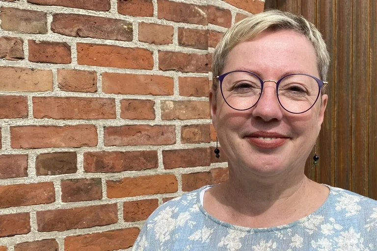 Eine Frau lächelt in die Kamera.