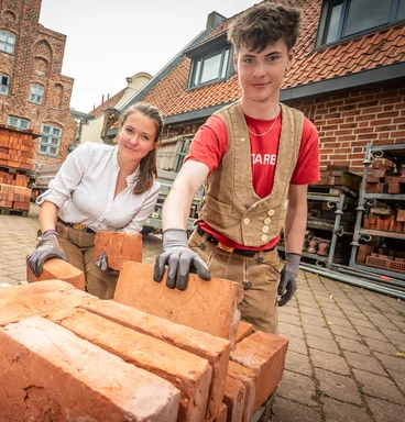 Azubis der Kirchenbauhütte sortieren Backsteine