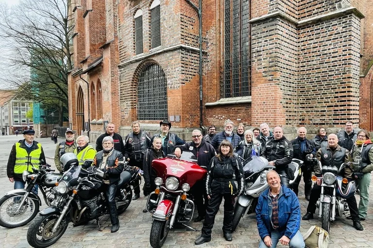 Menschen mit Motorrädern vor einer Kirche