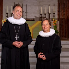 Zwei pastorale Personen in einer Kirche
