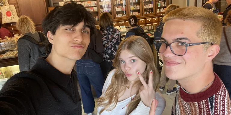 Drei junge Menschen gucken verschmitzt in die Kamera.