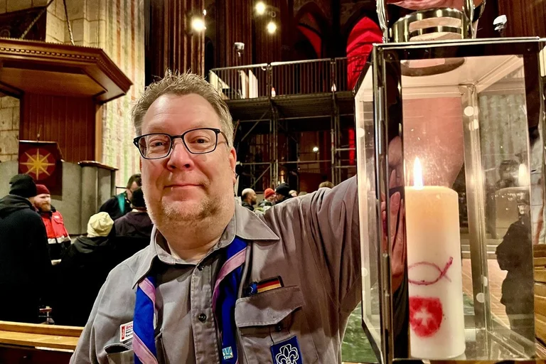 Ein Mann hält eine Laterne mit einer Kerze