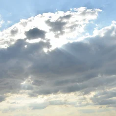 Sonne hinter Wolken mit blauem Himmel